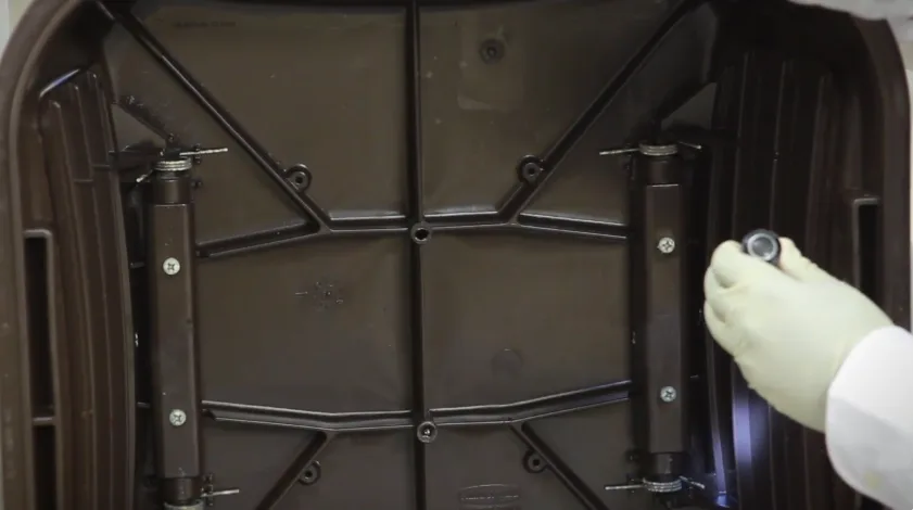 Close-up of the underside of a bait station lid and its trap mechanism