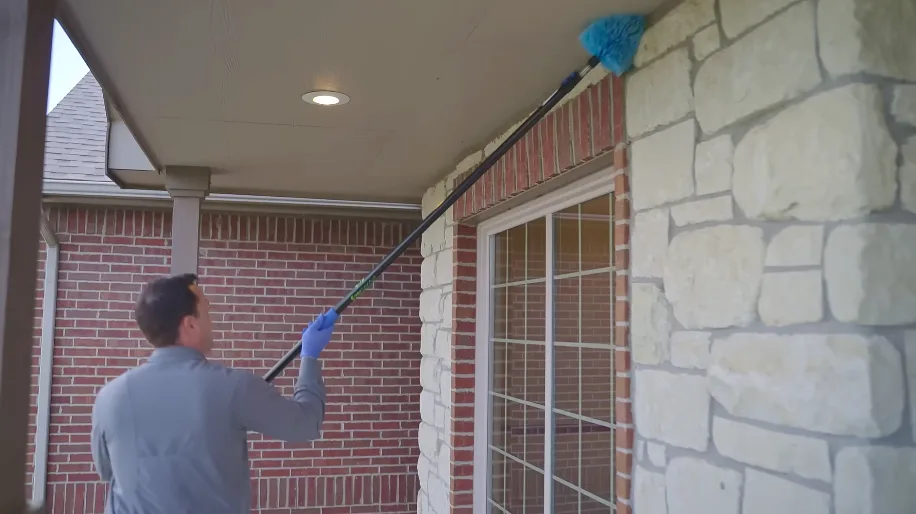Technician reaching a high soffit run with an extension pole