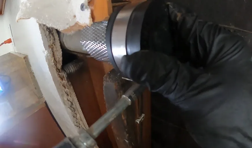 Fastening mesh screen over a wall opening with a drill to seal it against rodents