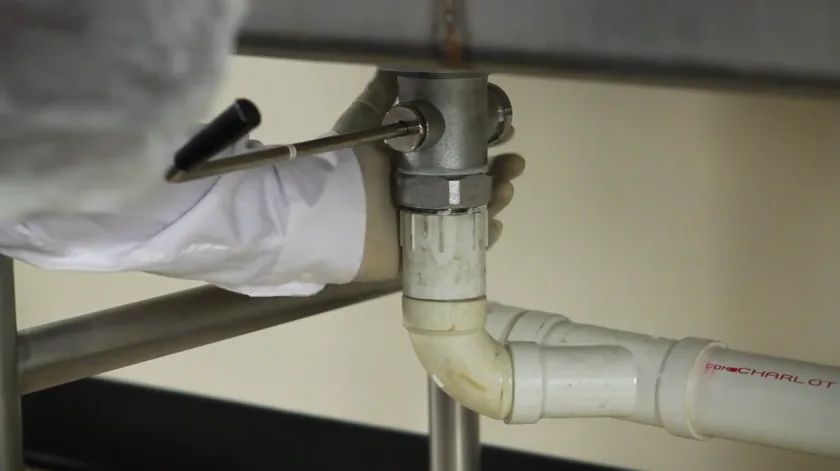 Pipe penetration under a sink where the supply lines pass through the wall