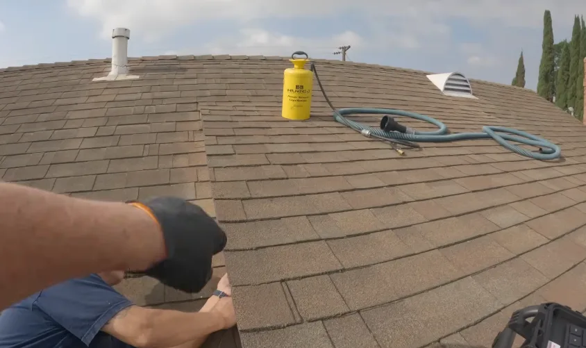 Working across a shingle roof with a sprayer while treating roof line access points