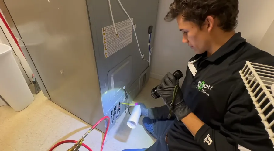 Technician shining a light into a wall return-air grille during an inspection