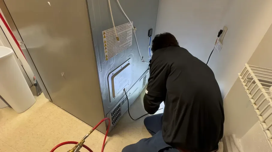 Technician feeding a hose to a wall vent grille during treatment